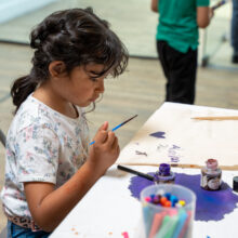 young girl painting at aid party